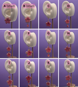 Flower earrings displayed on mannequin ears with labels against a purple background