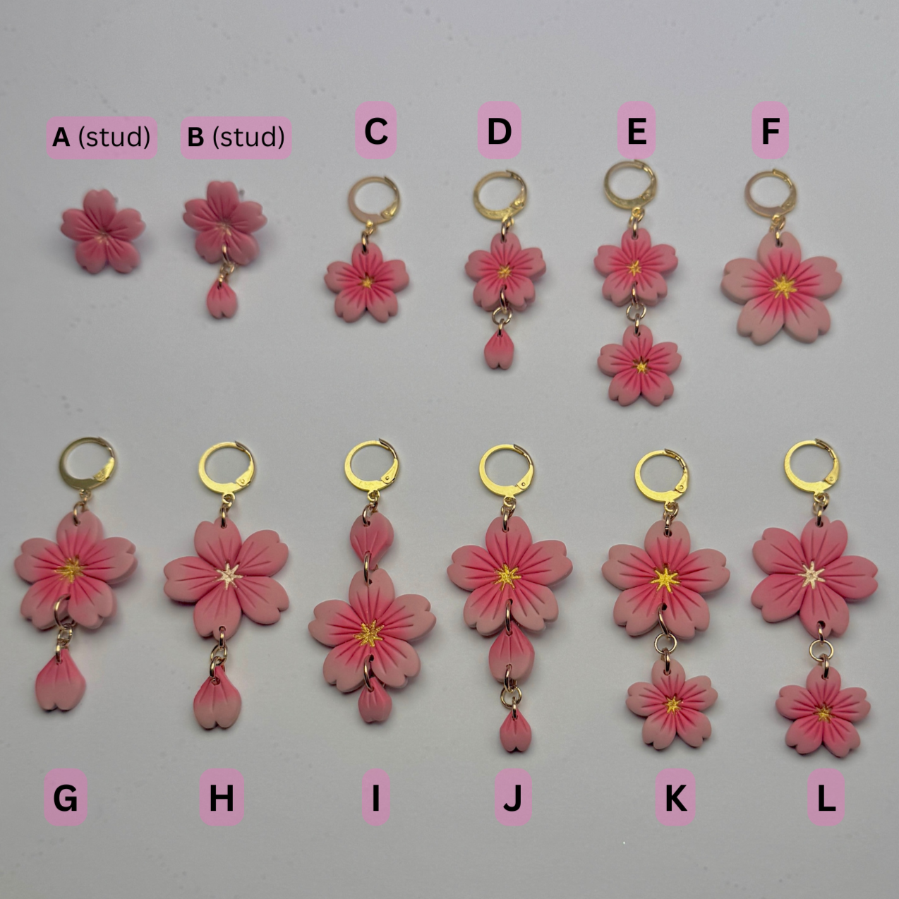 Set of pink flower earrings with gold accents on a gray background